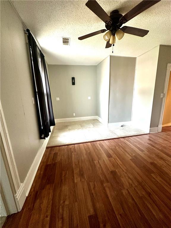 unfurnished bedroom with ceiling fan, hardwood / wood-style floors, and a textured ceiling