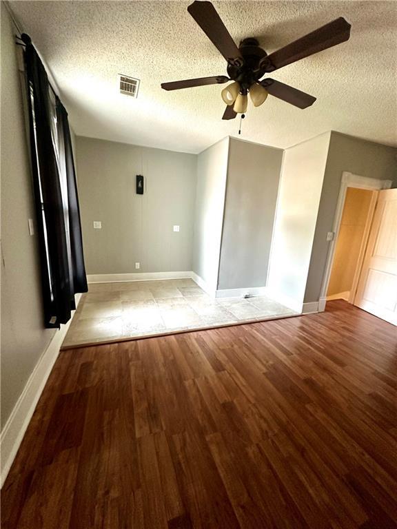 interior space with ceiling fan, hardwood / wood-style flooring, and a textured ceiling