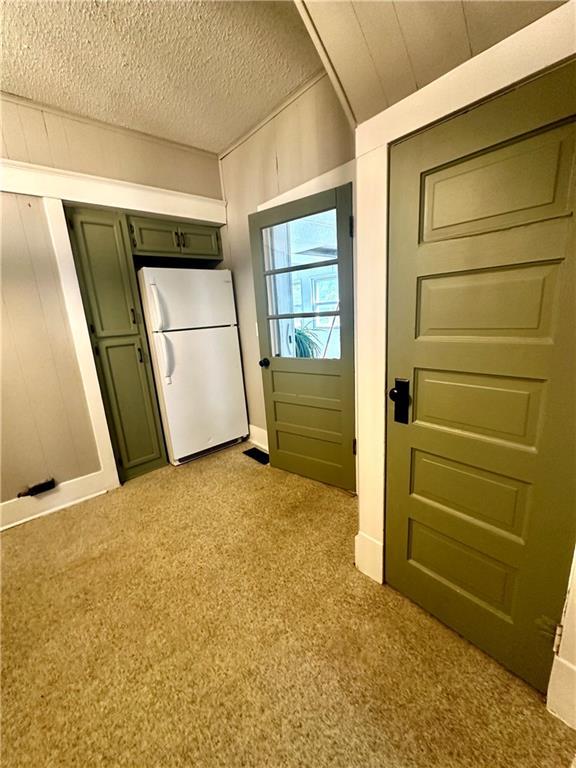 interior space with a textured ceiling and light colored carpet