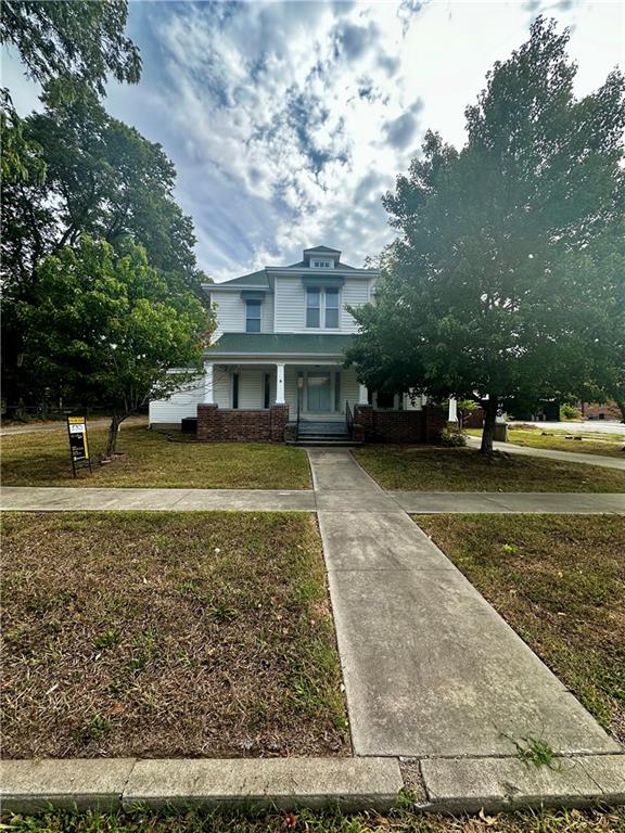 view of front of home with a front yard and covered porch