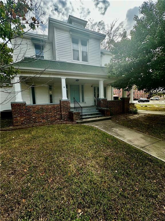 view of front of property with covered porch and a front yard