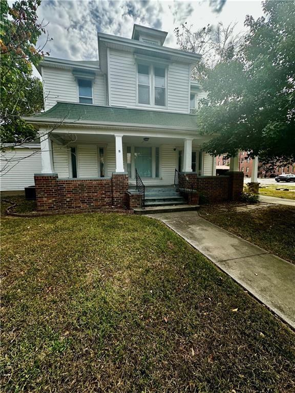 view of front of property featuring a porch and a front lawn