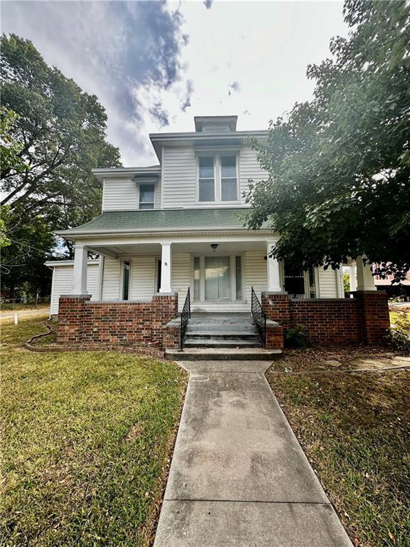 view of front of house with a porch and a front yard