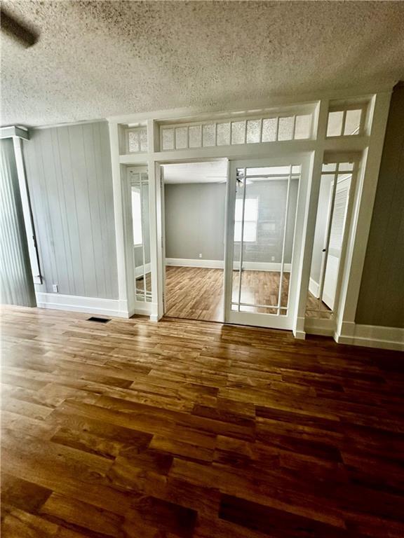 interior space featuring a textured ceiling and hardwood / wood-style floors