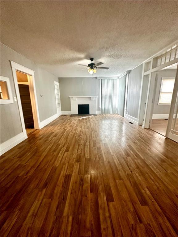 unfurnished living room featuring a textured ceiling, ceiling fan, and hardwood / wood-style flooring