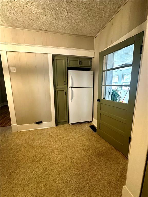 doorway featuring light carpet and a textured ceiling