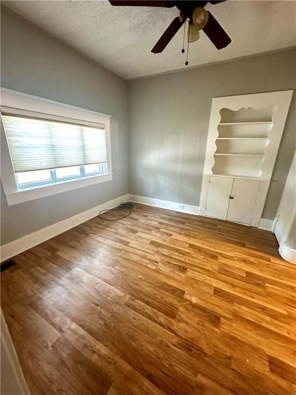 unfurnished bedroom featuring a textured ceiling, light hardwood / wood-style floors, and ceiling fan