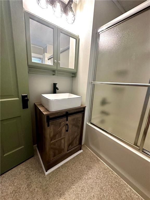 bathroom featuring enclosed tub / shower combo and vanity