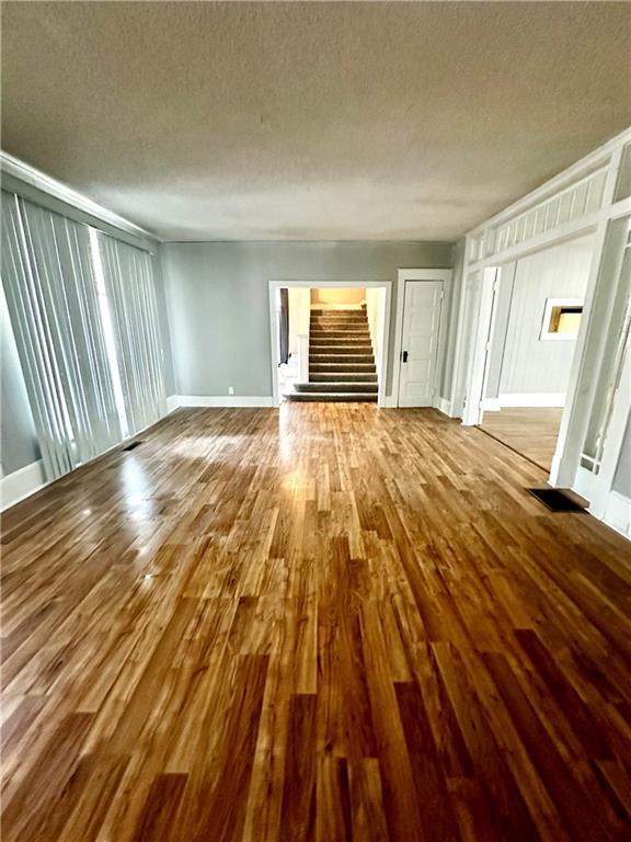 unfurnished living room featuring wood-type flooring and a textured ceiling