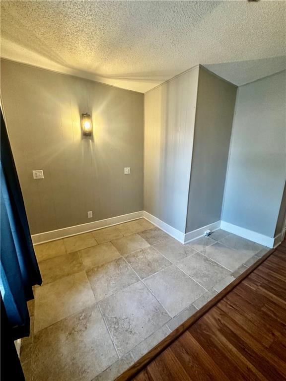 empty room featuring a textured ceiling and light wood-type flooring