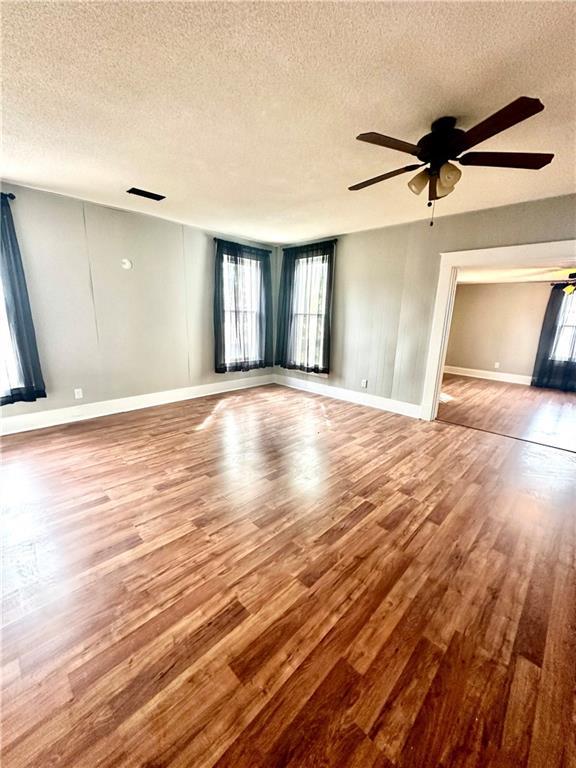 interior space featuring ceiling fan, hardwood / wood-style flooring, and a textured ceiling