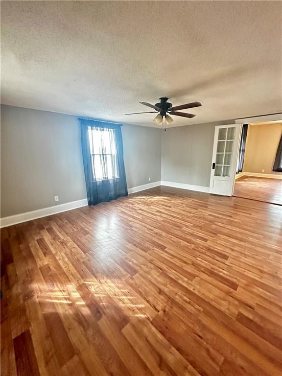 spare room with a textured ceiling, hardwood / wood-style floors, and ceiling fan