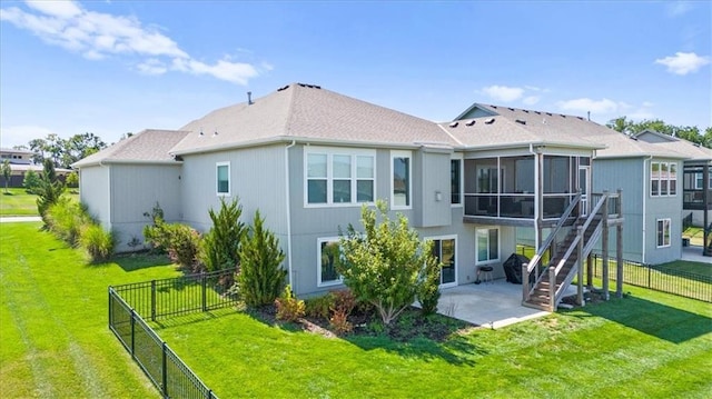 rear view of house featuring a sunroom, a lawn, and a patio area