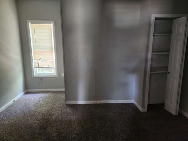 unfurnished bedroom with dark carpet