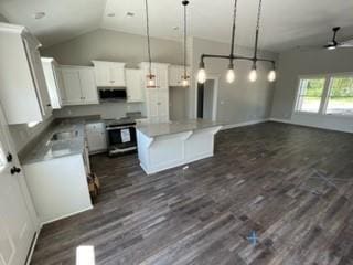 kitchen with stove, vaulted ceiling, decorative light fixtures, a kitchen island, and dark hardwood / wood-style flooring