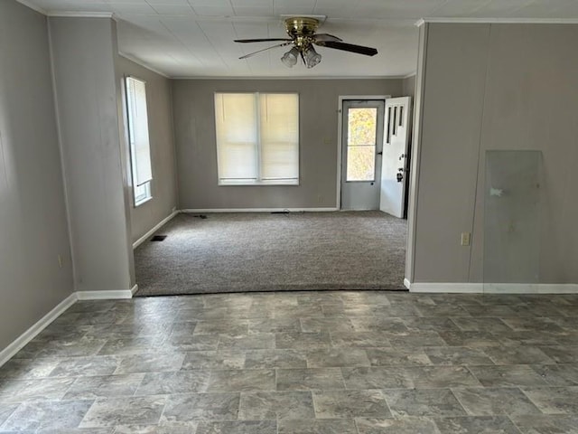 spare room with ornamental molding, carpet, and ceiling fan