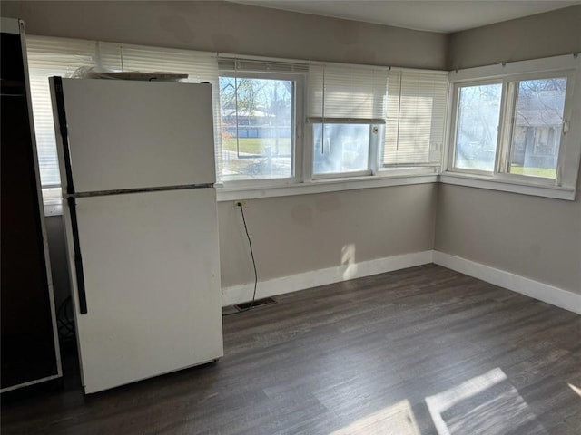 unfurnished dining area with dark wood-type flooring