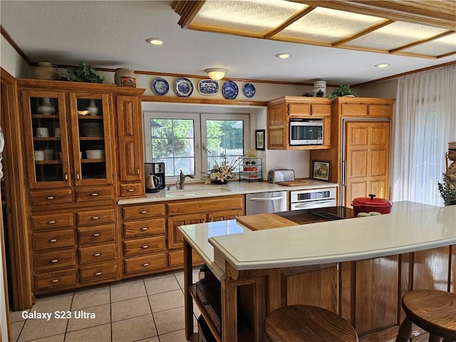 kitchen featuring sink, crown molding, stainless steel appliances, and light tile patterned flooring