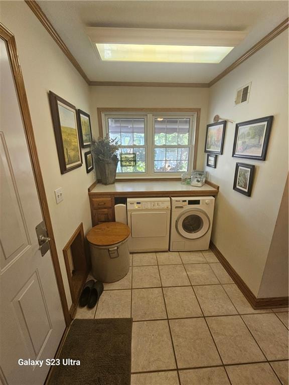 laundry room with crown molding, separate washer and dryer, and light tile patterned floors