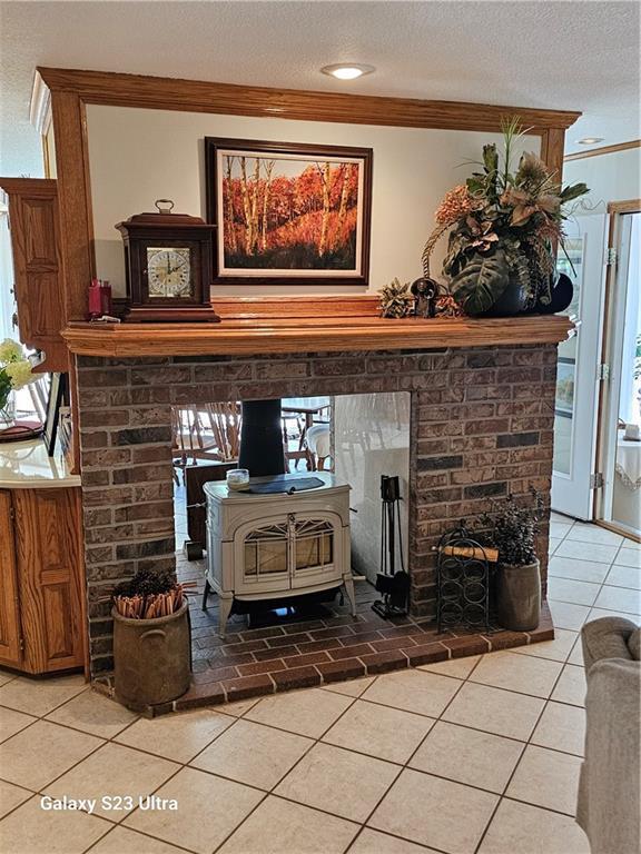 interior details with crown molding, a textured ceiling, and a wood stove