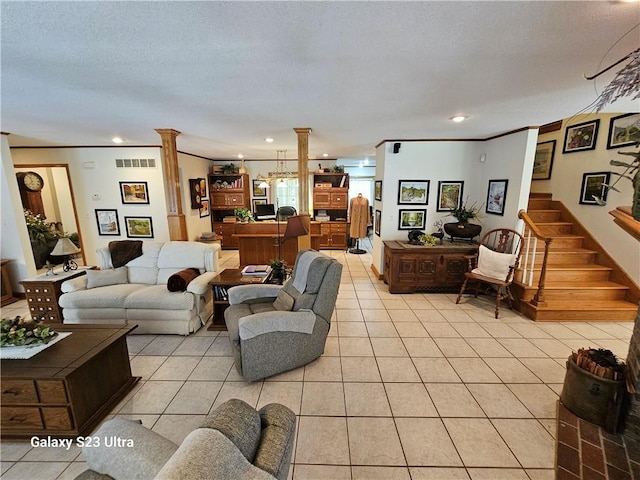 tiled living room featuring crown molding, decorative columns, and a textured ceiling