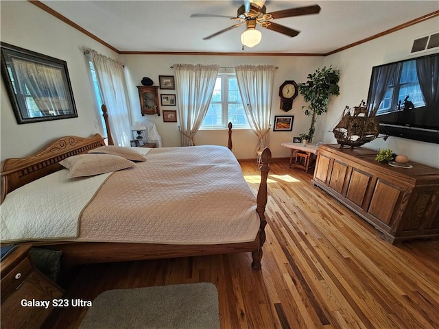 bedroom featuring crown molding, light hardwood / wood-style flooring, and ceiling fan