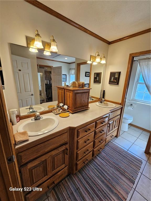 bathroom featuring vanity, ornamental molding, tile patterned floors, and toilet