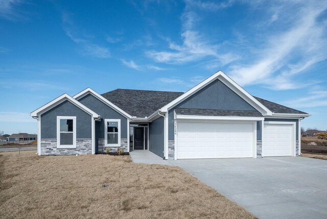 craftsman-style home featuring a garage and a front lawn