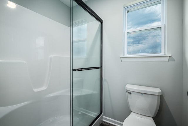 bathroom featuring toilet and a shower stall