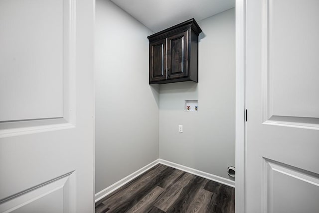 washroom with cabinet space, baseboards, washer hookup, and dark wood finished floors