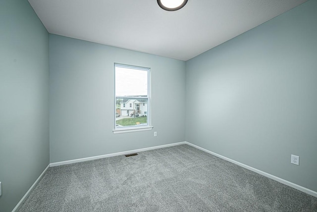 unfurnished room with visible vents, baseboards, and carpet flooring