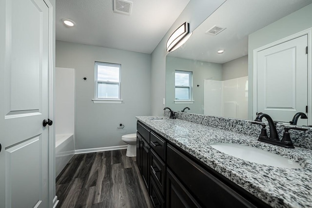 full bathroom featuring a healthy amount of sunlight, visible vents, and a sink