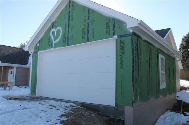 view of snow covered exterior featuring a garage