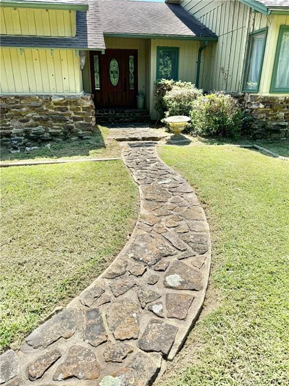 entrance to property featuring a yard