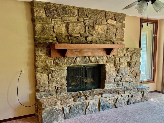 interior details with carpet flooring, ceiling fan, and a fireplace