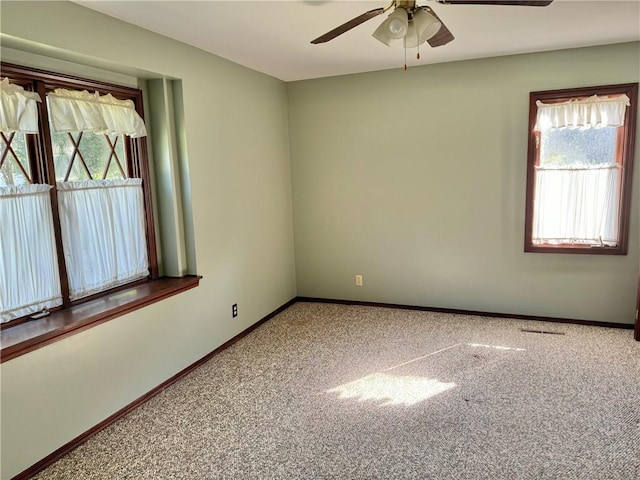 carpeted empty room featuring plenty of natural light and ceiling fan