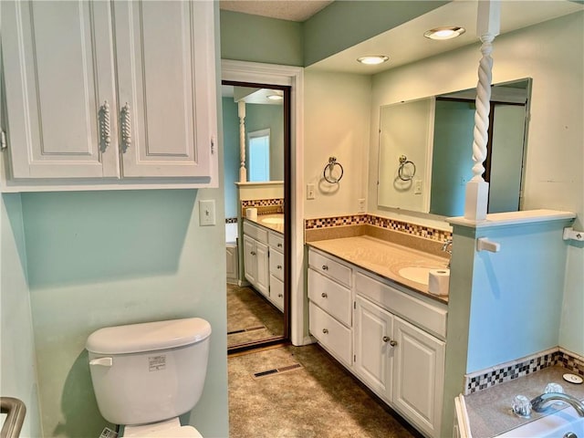 bathroom featuring vanity and toilet