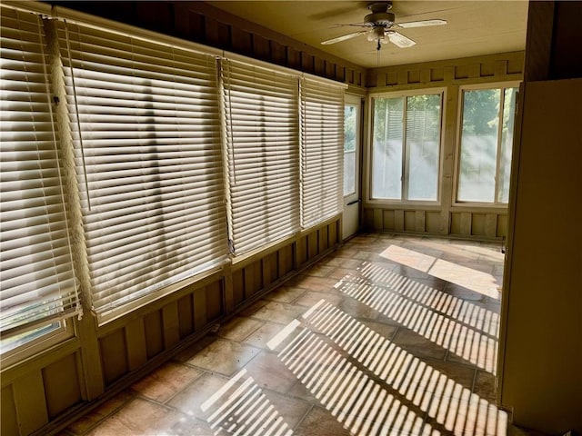 unfurnished sunroom with ceiling fan