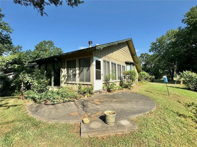 back of house with a patio area and a yard