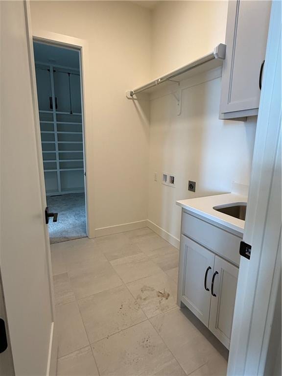 clothes washing area featuring sink, hookup for a washing machine, cabinets, and hookup for an electric dryer