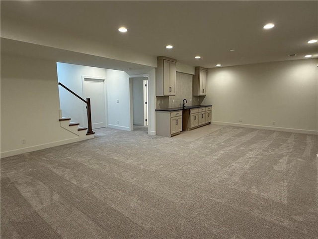 unfurnished living room with sink and light carpet