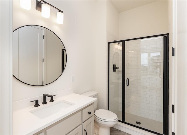 bathroom with vanity, toilet, and a shower with shower door