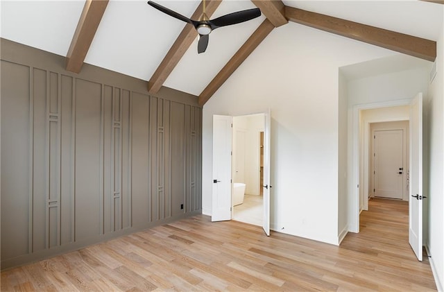 unfurnished bedroom featuring ensuite bath, light hardwood / wood-style flooring, ceiling fan, high vaulted ceiling, and beamed ceiling