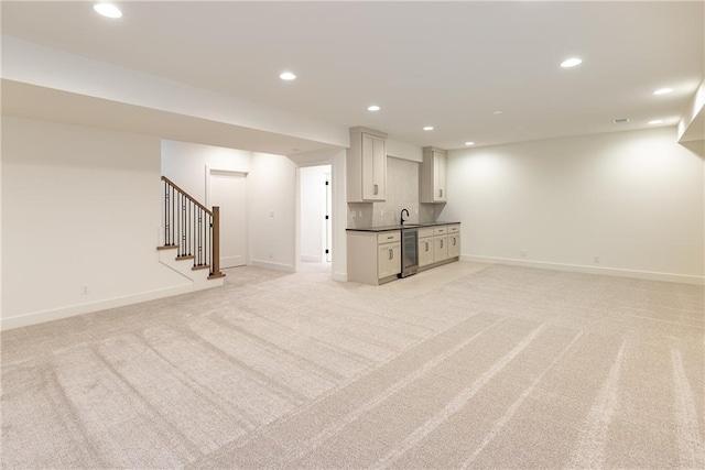 basement featuring wine cooler, sink, and light colored carpet