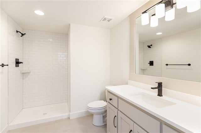 bathroom featuring tiled shower, vanity, and toilet