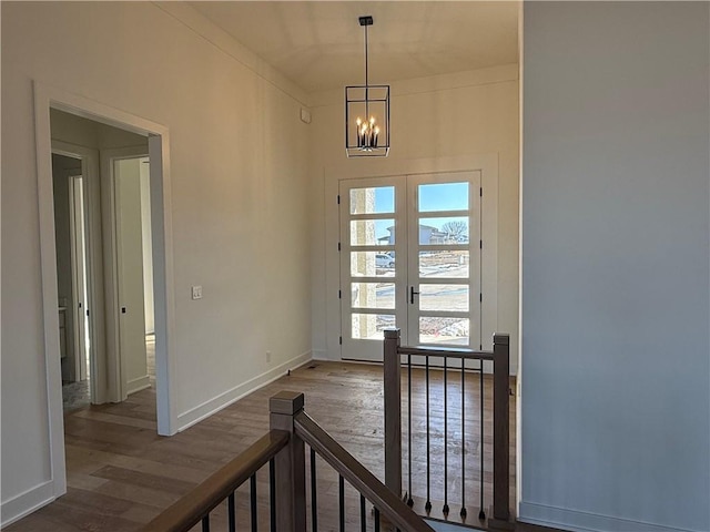 entrance foyer with dark wood-style floors, french doors, baseboards, and an inviting chandelier