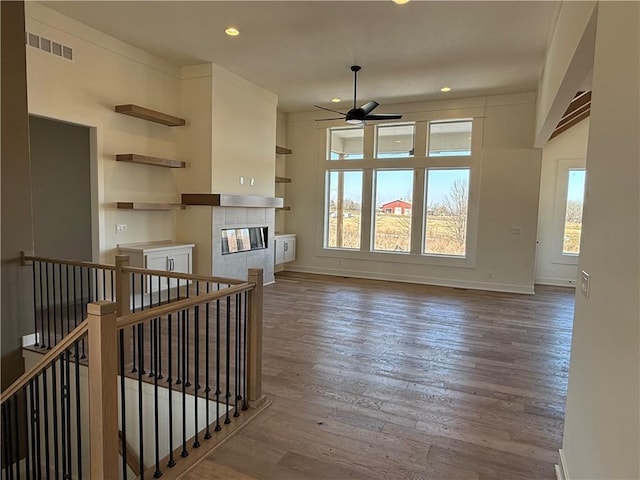 living room featuring visible vents, baseboards, a ceiling fan, wood finished floors, and recessed lighting