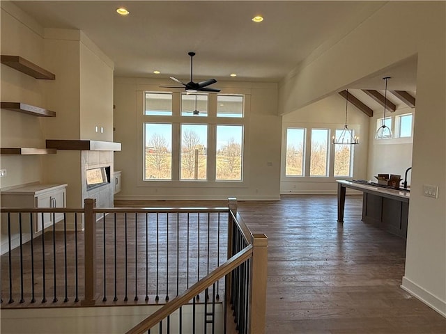 interior space featuring baseboards, dark wood-type flooring, vaulted ceiling with beams, and recessed lighting