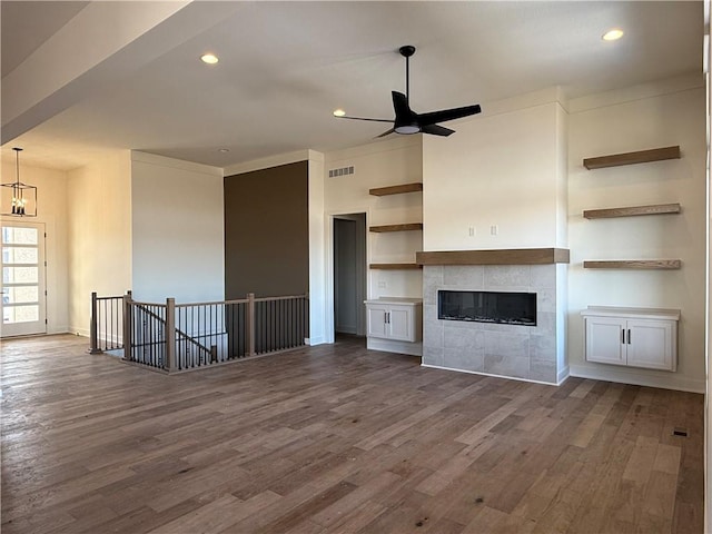 unfurnished living room with dark wood-type flooring, a fireplace, visible vents, and recessed lighting