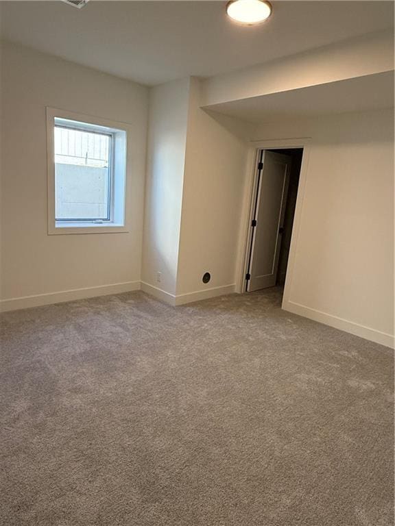 carpeted empty room featuring baseboards